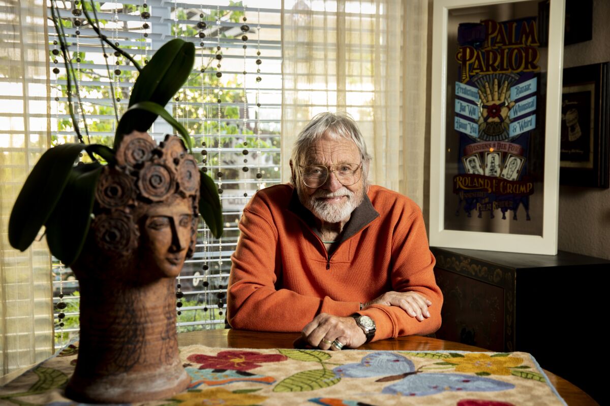 Rolly Crump sits beside a large pottery sculpture.