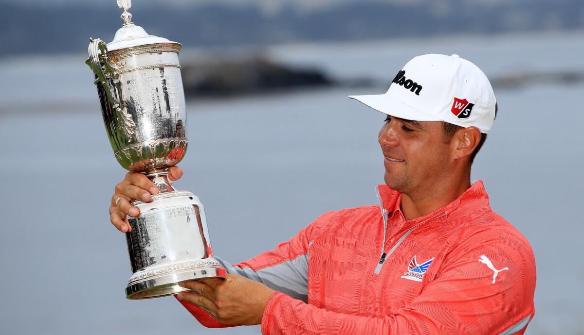 Gary Woodland hoists the winner's trophy at the U.S. Open on Sunday.