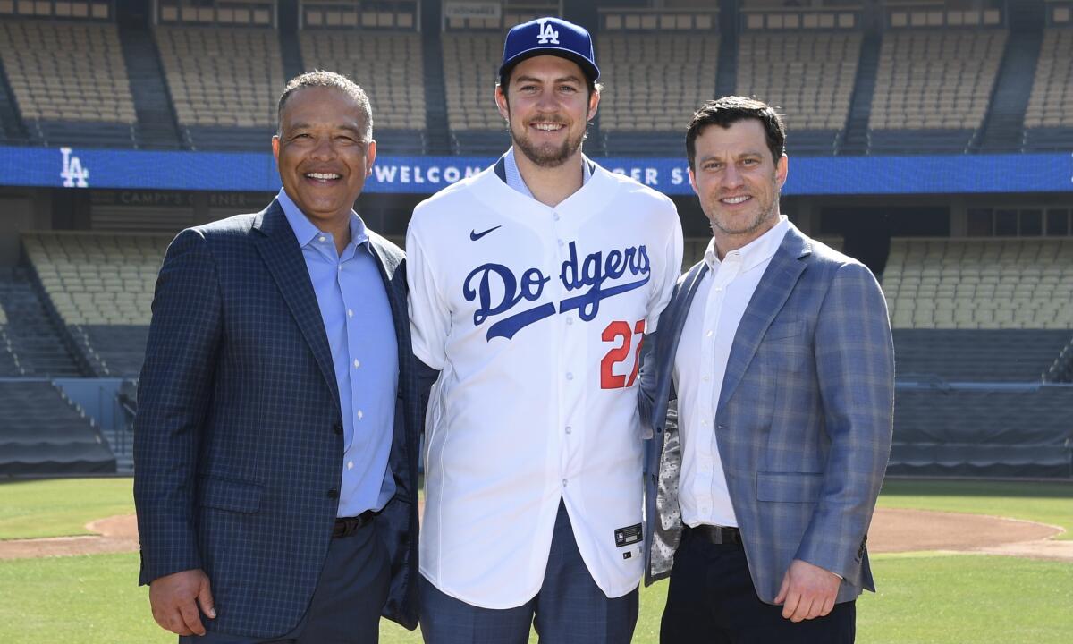 Trevor Bauer, center, stands next to Dodgers manager Dave Roberts and Andrew Friedman.