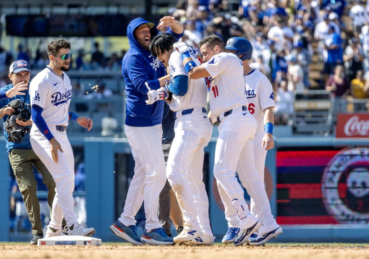 Shohei Ohtani is swarmed by teammates after his first walk-off hit as a Dodger.