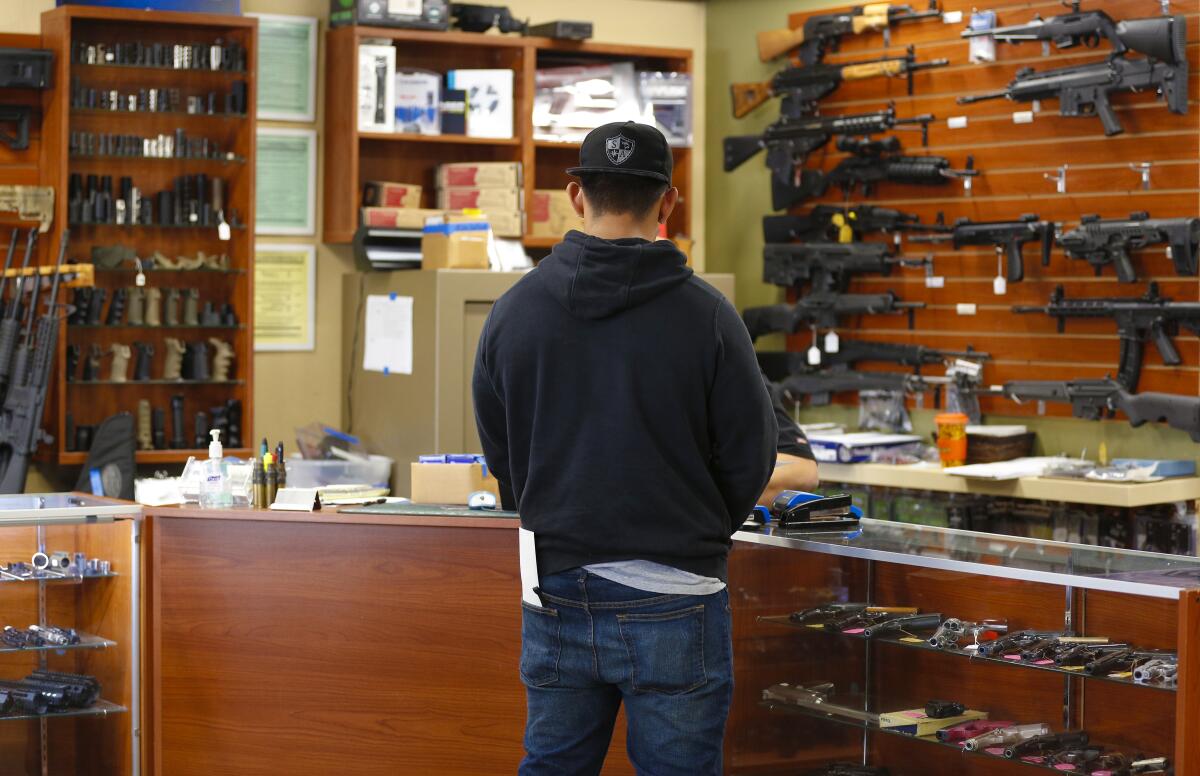 A customer shops for a gun at AO Sword Firearms in El Cajon in March 2020. 
