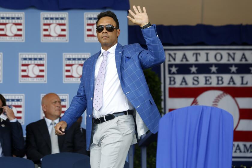 Hall of Famer Roberto Alomar waves as he arrives for an induction ceremony July 26, 2015, in Cooperstown, N.Y.
