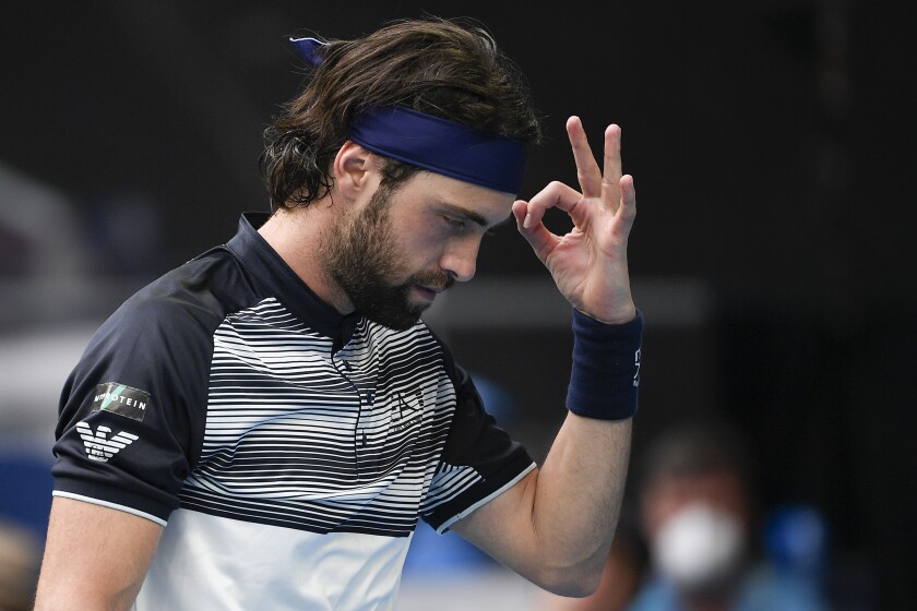 FILE - Nikoloz Basilashvili of Georgia gestures during his first round match against Andy Murray of Britain at the Australian Open tennis championships in Melbourne, Australia, Tuesday, Jan. 18, 2022. On Friday, Jan. 21, The Associated Press reported on stories circulating online incorrectly claiming three tennis players, Basilashvili, Nick Kyrgios and Dalila Jakupovic — were forced to drop out of this year’s Australian Open after they experienced chest-related health issues.(AP Photo/Andy Brownbill)