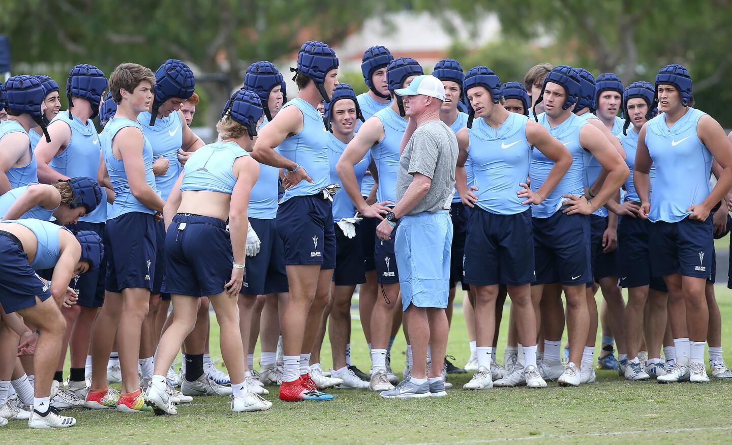 Head coach Dan O'Shea gathers players before a water break during a spring football showcase at Corona del Mar High on Wednesday.