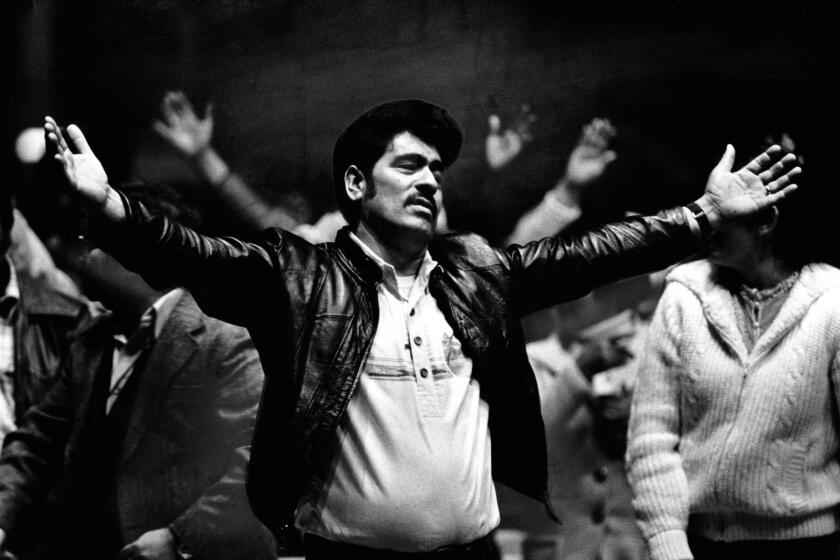 March 20, 1983: Alathough evangelical Protestantism has made inroads among Latinos, the Catholic Church has also found new enthusiasm. In this photo a Charismatic Catholic espresses himself at Olympic Auditorium.