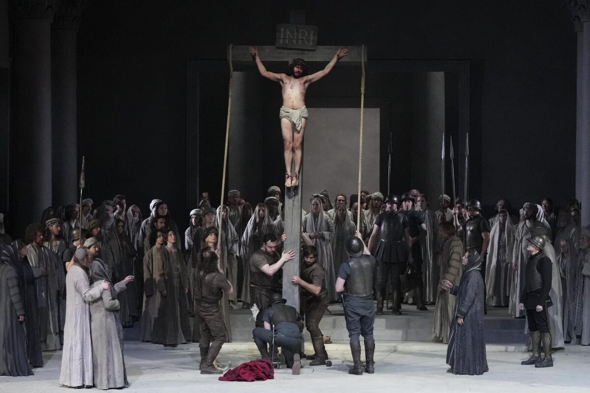 Rochus Rueckel as Jesus and cast members perform during the rehearsal of the 42nd Passion Play in Oberammergau, Germany, Wednesday, May 4, 2022. After a two-year delay due to the coronavirus, Germany's famous Oberammergau Passion Play is opening soon. The play dates back to 1634, when Catholic residents of a small Bavarian village vowed to perform a play of the last days of Jesus Christ every 10 years, if only God would spare them of any further Black Death victims. (AP Photo/Matthias Schrader)