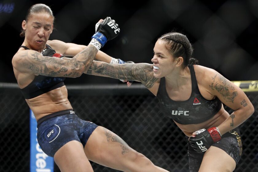 Amanda Nunes, right, hits Germaine de Randamie in a mixed martial arts women's bantamweight championship bout at UFC 245, Saturday, Dec. 14, 2019, in Las Vegas. (AP Photo/John Locher)