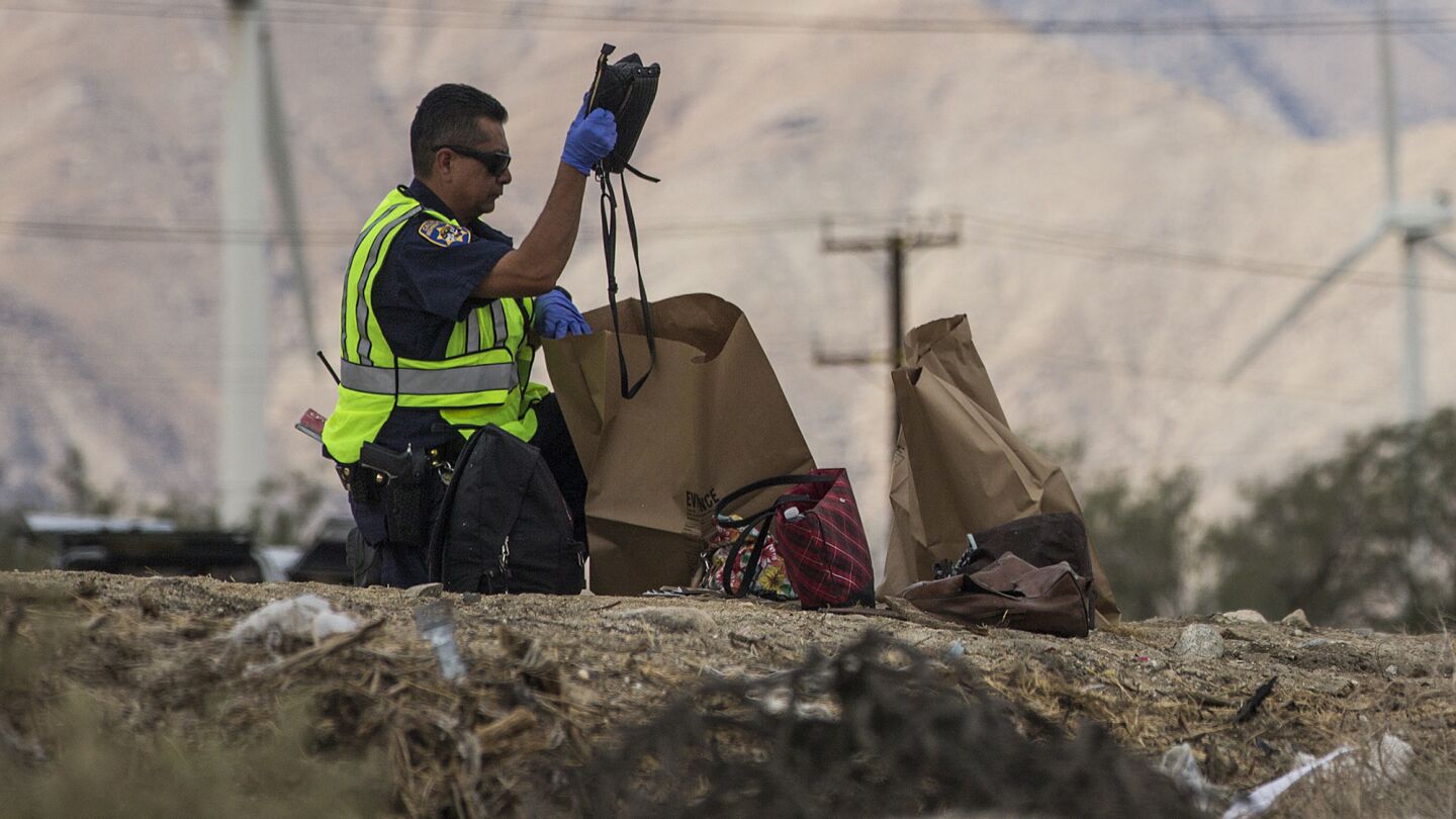A CHP officer packs purses and backpacks into brown paper bags.