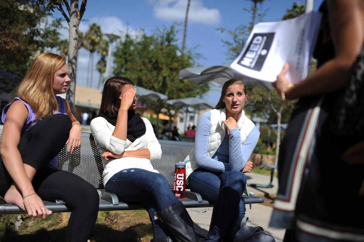 Students Amanda McComas, left, Rose Marie Chute and Sari Schwartz discuss Obamacare with Lisa Fiori, a supporter of the Affordable Care Act, at an education and awareness event on the law on the campus of Santa Monica City College.