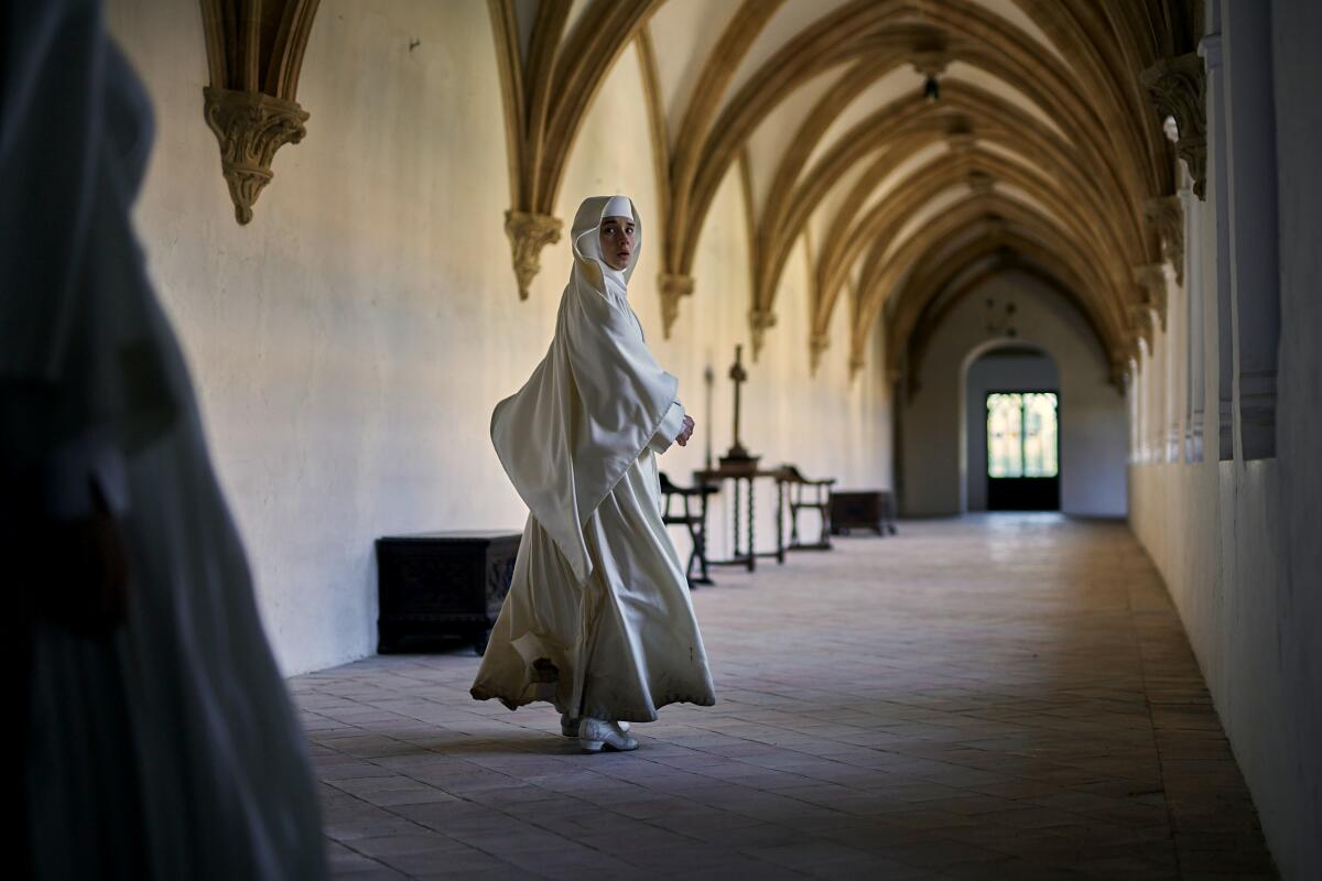 A nun runs down a hallway.