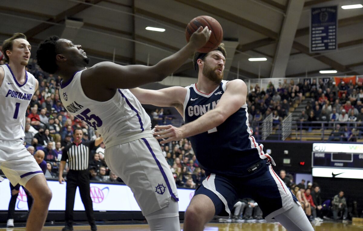 Gonzaga forward Drew Timme, right, pushes Portland forward Chika Nduka, left, as the go after a rebound during the first half of an NCAA college basketball game in Portland, Ore., Saturday, Jan. 28, 2023. (AP Photo/Steve Dykes)