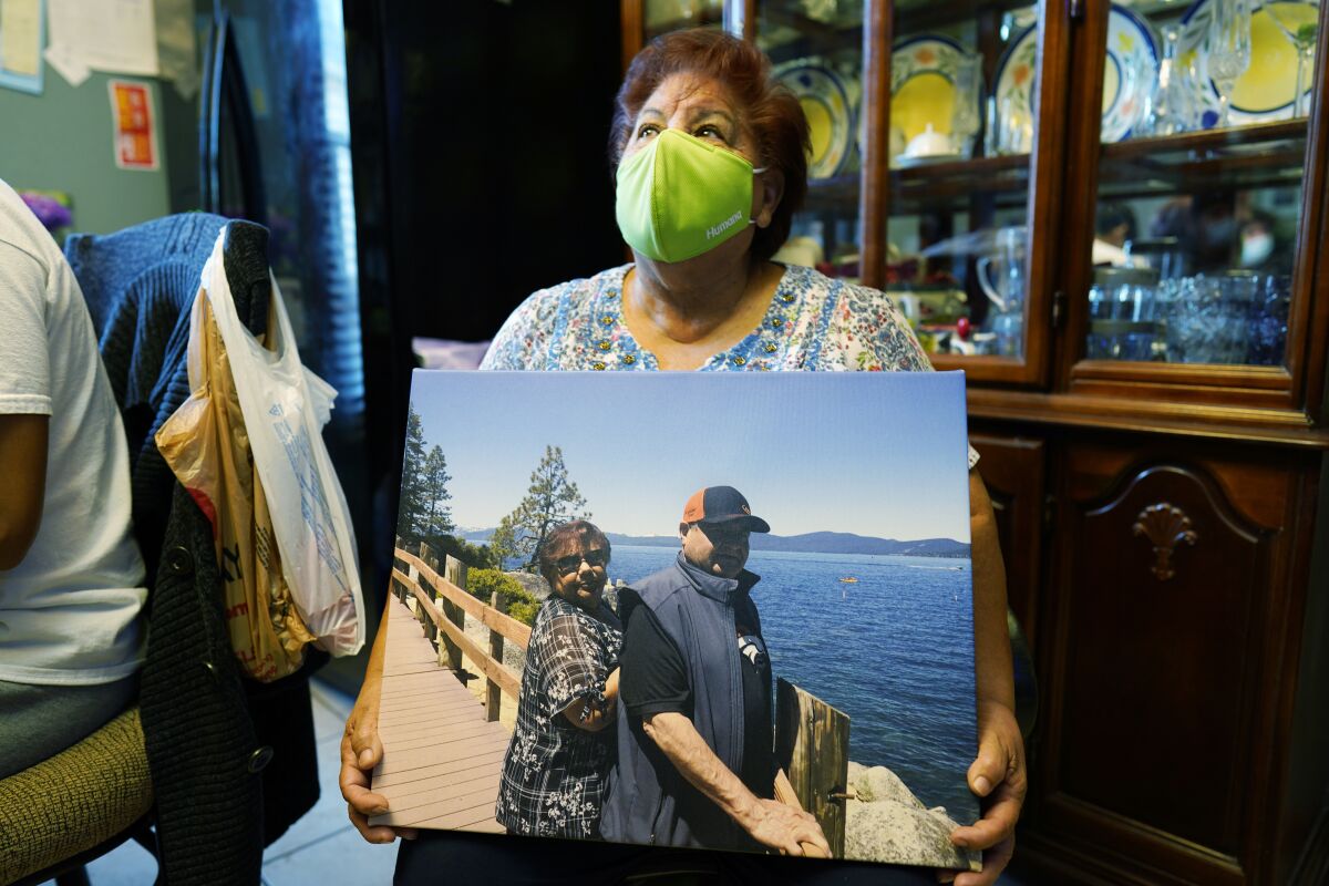 Carolina Sanchez holds a photograph of her husband, Saul, and her taken in 2019 at Lake Tahoe, Nev., during an interview Monday, Oct. 12, 2020, in the family home in Greeley, Colo. (AP Photo/David Zalubowski)