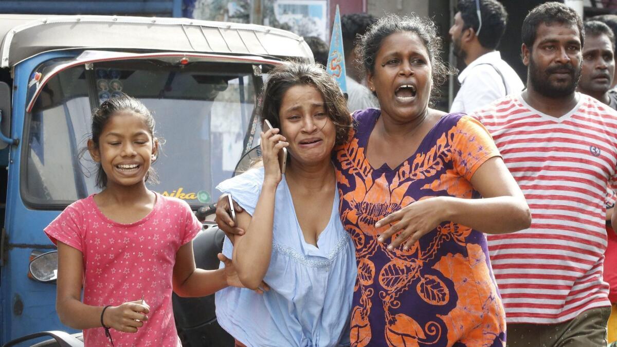People run for safety as authorities announce an evacuation Monday after a van containing explosives was found near a church in Colombo.