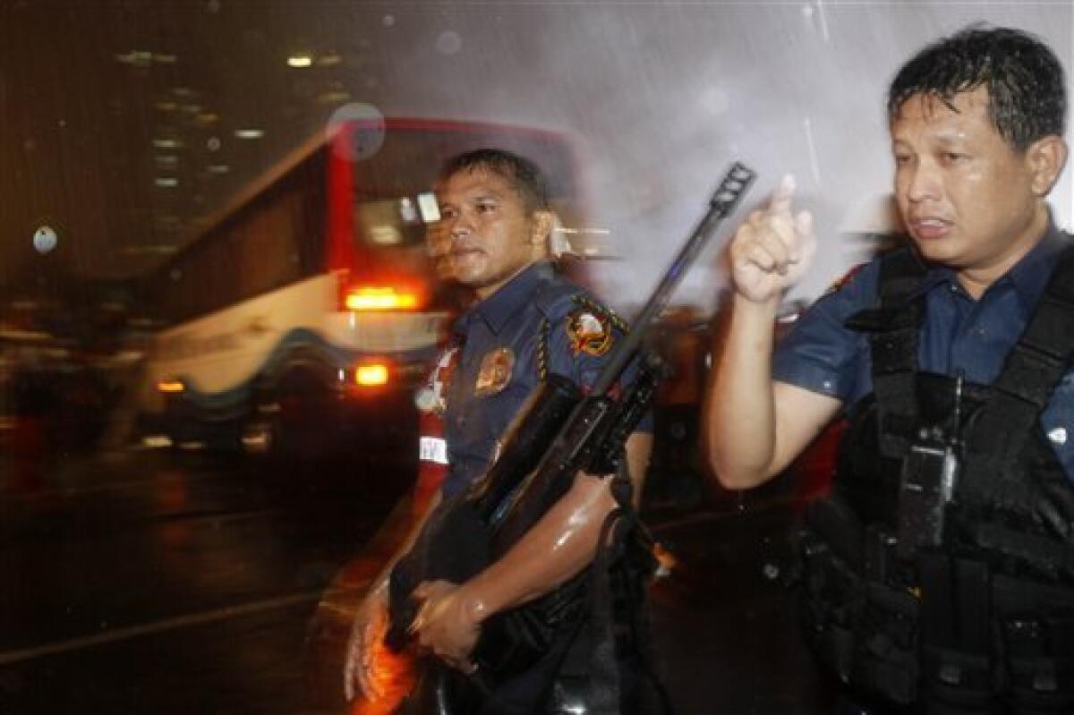 Police and SWAT members secure the scene following an assault on a tourist bus with foreign tourists taken hostage by a dismissed police officer at Manila's Rizal Park Monday, Aug. 23, 2010 in Manila, Philippines. Philippine police stormed the bus Monday evening after shots were heard from the hostage-taker of 15 Chinese tourists, and at least four of the hostages crawled out of the back door. (AP Photo/Bullit Marquez)