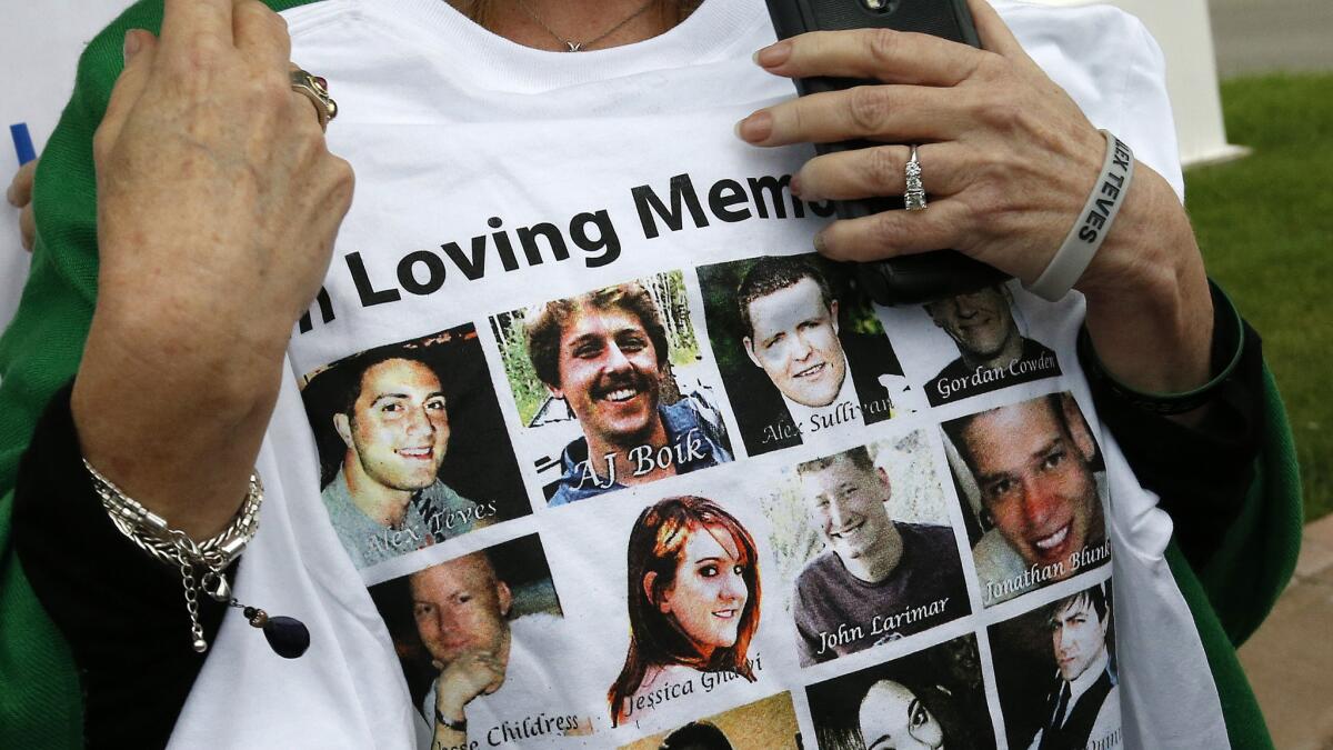 Sandy Phillips, whose daughter Jessica Ghawi died in the 2012 Aurora movie theatre massacre, carries a T-shirt memorializing the 12 people killed outside the courthouse in Centennial, Colo., where James Holmes is being tried for murder.