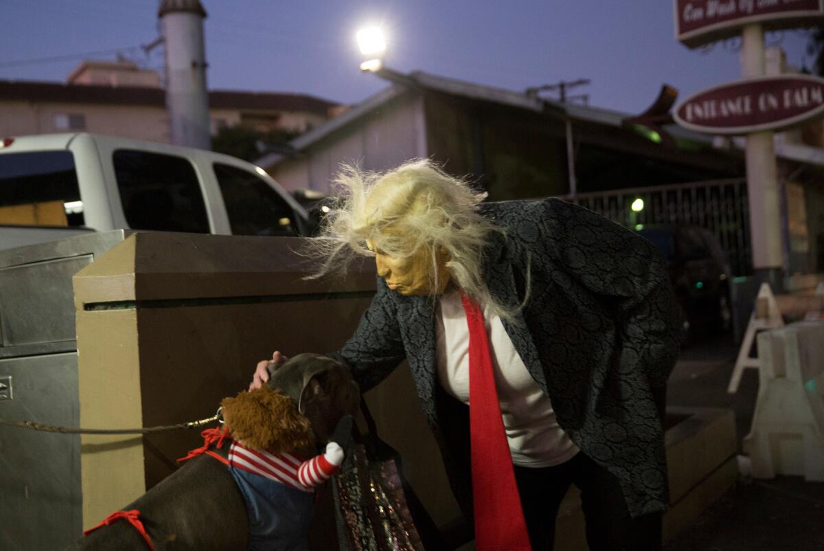Chucky de la película "Child's Play' y un transeúnte luciéndo una máscara de Donald Trump.