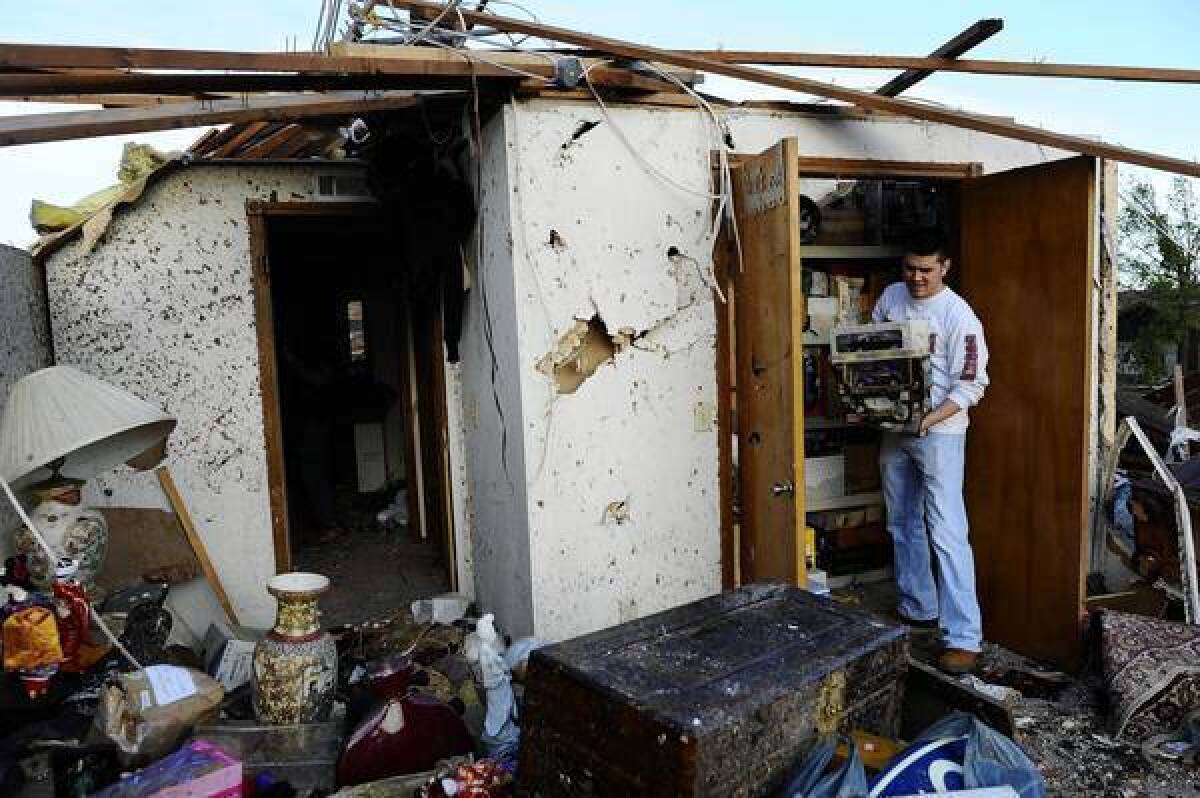 A man salvages what he can from his grandmother's home in Moore, Okla.