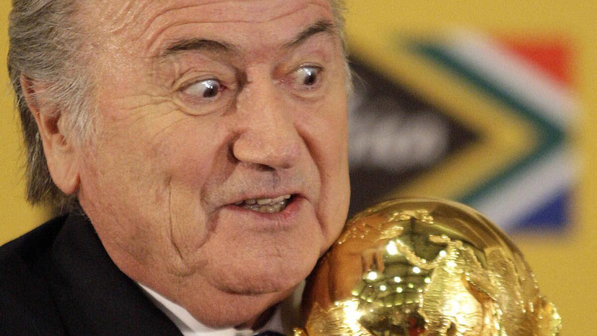 FIFA President Sepp Blatter holds the World Cup trophy during a news conference in Pretoria, South Africa, on June 6, 2010.