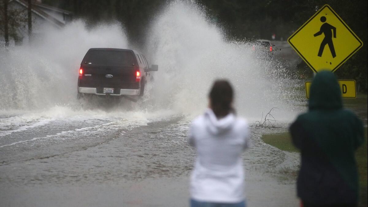 People watch as a truck drives into floodwater in Wilmington, N.C., on Sunday.