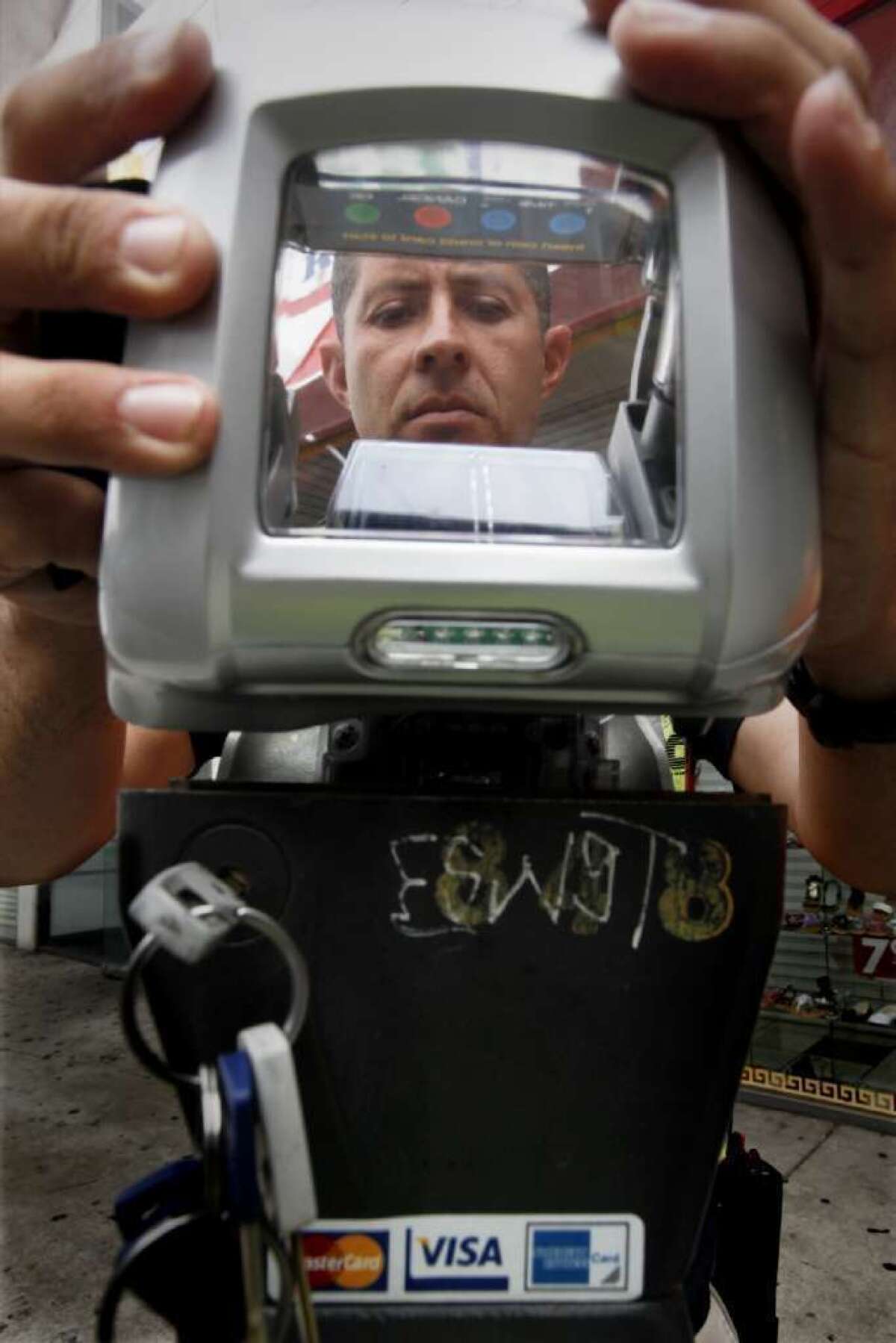 A technician reassembles a parking meter in Los Angeles that had been jammed with a wire and a gum wrapper by someone trying to beat payment in 2010. A state bill would prevent cities from ticketing drivers who park at broken meters.