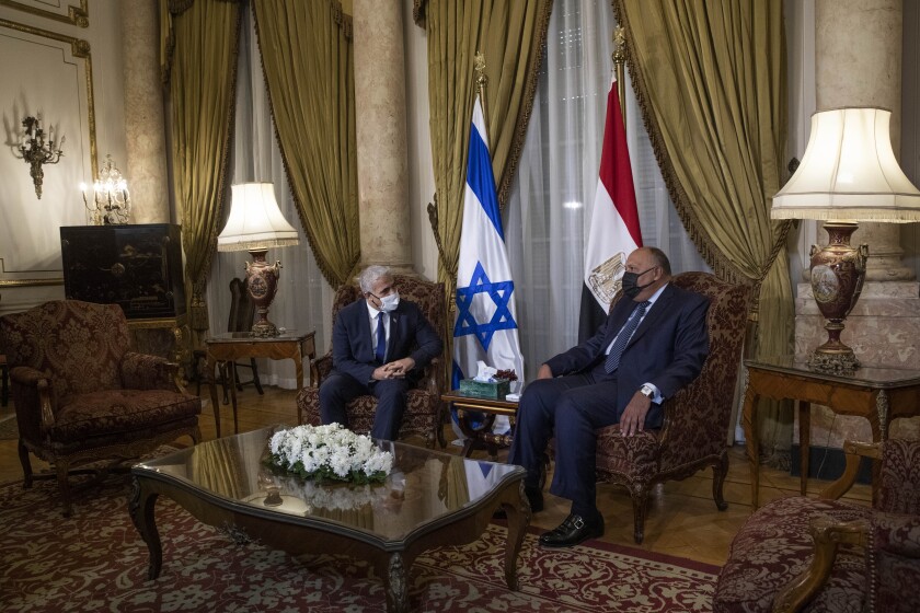 Israeli Foreign Minister Yair Lapid, left, meets with Egyptian Foreign Minister Sameh Shoukry at the Tahrir Palace in Cairo, Egypt, Thursday, Dec. 9, 2021. (AP Photo/Nariman El-Mofty)