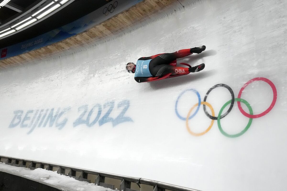 Fan Duoyao of China speeds past the Olympic rings during a men's luge training run on Wednesday.
