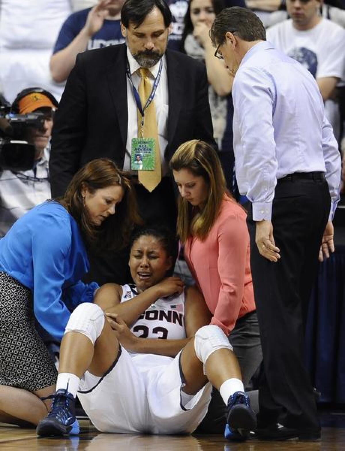 UConn star Kaleena Mosqueda-Lewis is attended to by team staff after suffering an elbow injury in the Huskies' win over Stanford on Monday.