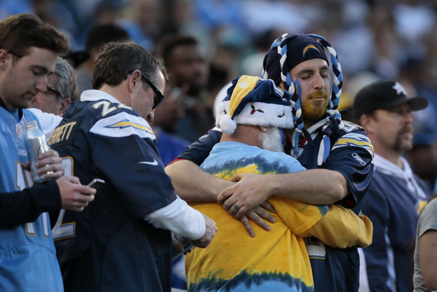 Mitchell Pellegrin (center) hugs son Justin as the final seconds tick off the clock in the Chargers' victory over the Dolphins on Sunday.