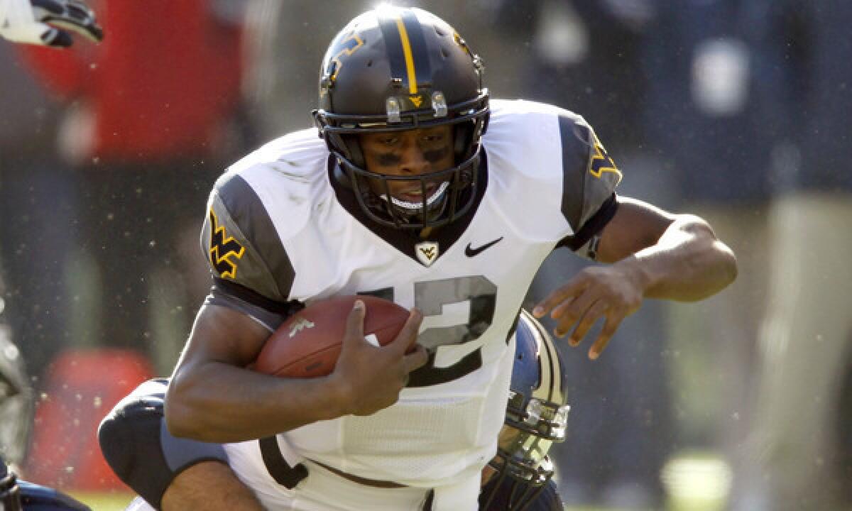 West Virginia's Geno Smith carries the ball during a 2010 game against Pittsburgh.