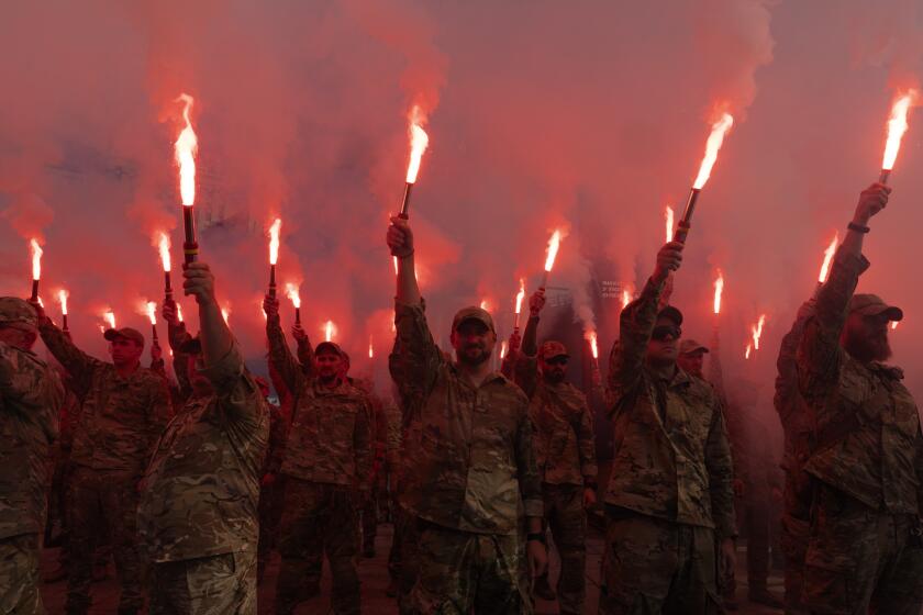 Soldados del batallón Azov de Ucrania encienden bengalas durante una manifestación para exigir la liberación de los prisioneros de guerra ucranianos que se encuentran cautivos en Rusia, en la Plaza de la Independencia en Kiev, Ucrania, el domingo 28 de julio de 2024. (Foto AP/Efrem Lukatsky)