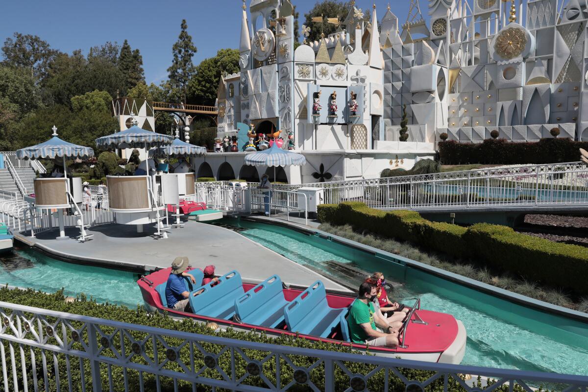 Three empty benches separate two occupied ones on a boat at Disneyland's It's a Small World.