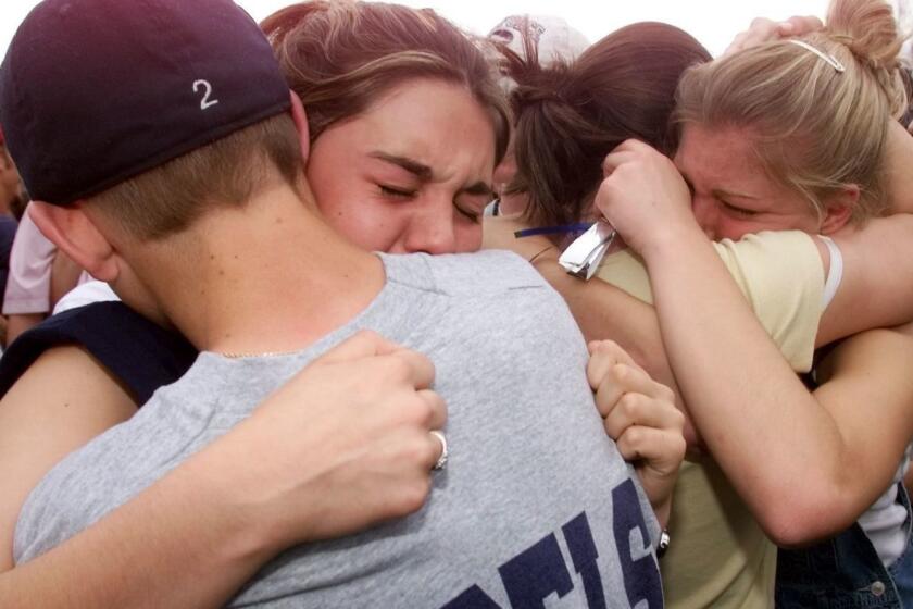 (FILES) In this file photo taken on April 21, 1999 students hug each other in the parking lot outside Columbine High School in Littleton, CO, the site of a school shooting on April 20,1999 where students and teachers where killed by two former students in a suicide mission. - This year marks the 20th anniversary of the Columbine High School shooting, when two youths aged 17 and 18 armed with guns and home-made bombs killed 12 students and a teacher at Columbine high school in Littleton, Colorado before they both committed suicide. (Photo by HECTOR MATA / AFP)HECTOR MATA/AFP/Getty Images ** OUTS - ELSENT, FPG, CM - OUTS * NM, PH, VA if sourced by CT, LA or MoD **