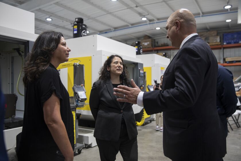 San Diego, CA - September 07: Rachel Luis y Prado, left, and her husband Hernan, right, give U.S. Small Business Administration Isabella Casillas Guzman gets a tour of VetPowered, a manufacturing facility in Barrio Logan, on Wednesday, Sept. 7, 2022 in San Diego, CA. (Ana Ramirez / The San Diego Union-Tribune)
