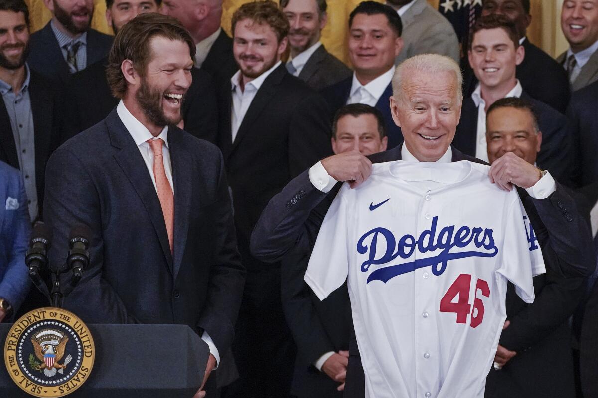 Clayton Kershaw, left, reacts as President Biden holds up a jersey during an event to honor the 2020 champion Dodgers.