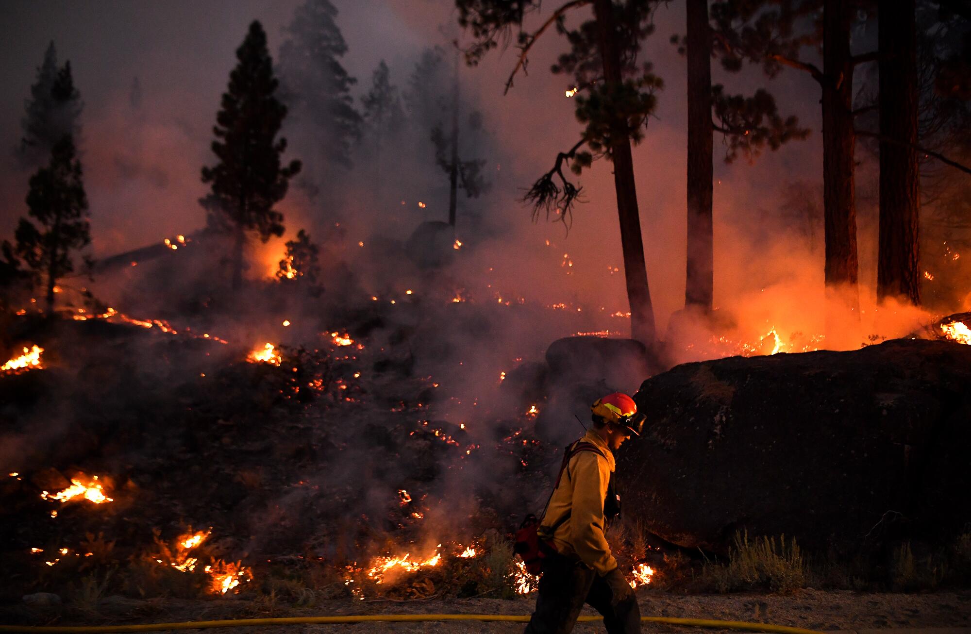 Firefighters battle the Caldor fire along Highway 89 west of Lake Tahoe