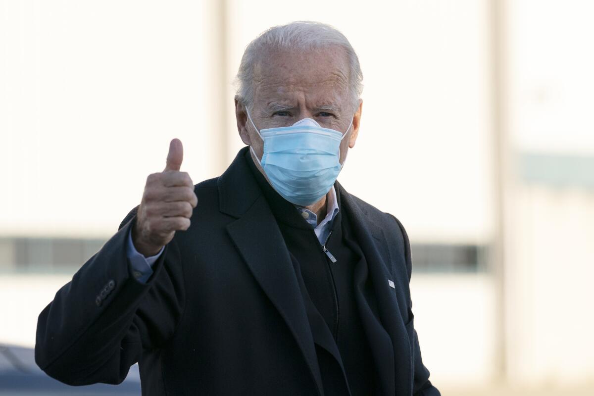 Joe Biden gives a thumbs-up as he boards his campaign plane in New Castle, Del.