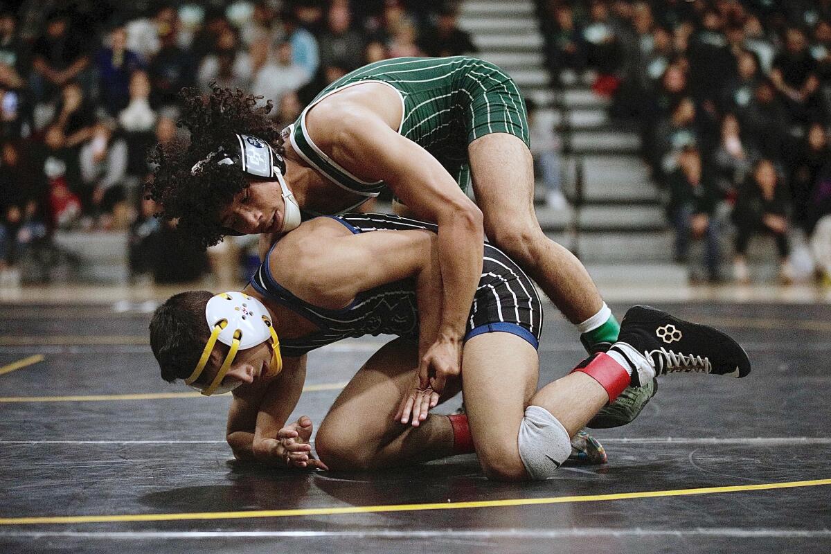 Canoga Park’s Adrian Escobar shoves Birmingham’s Aiden Martinez to the mat.