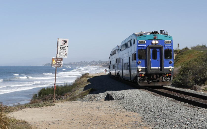 A Coaster train heads north along the bluffs in Del Mar where North County Transit District plans to install a fence.