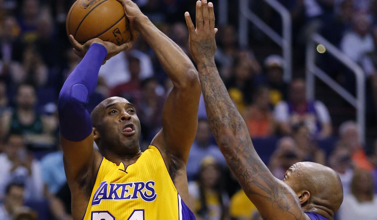 Lakers forward Kobe Bryant, left, shoots over Phoenix Suns forward P.J. Tucker during the first half on Wednesday.