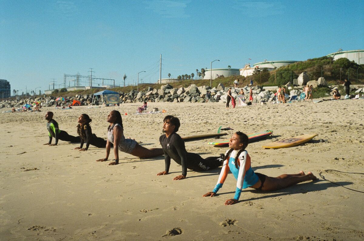 Surfers practice yoga before surfing at El Porto Beach. 