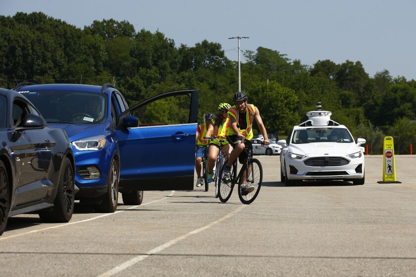 An Argo AI / Ford Motor robot test care avoids bicyclists on a test track.