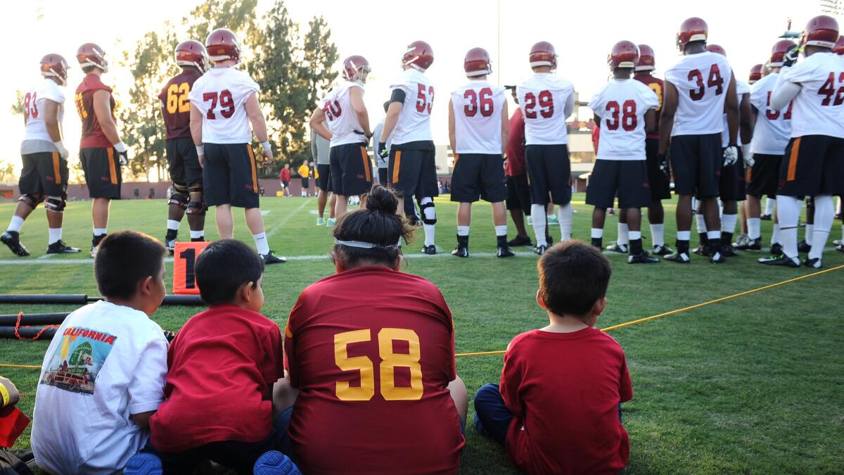 A group of USC fans look on as the Trojans take part in the first day of training camp Monday.