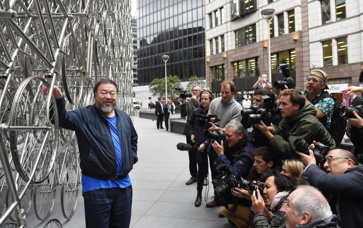 Chinese artist Ai Weiwei poses for photographers during the unveiling of his new sculpture "Forever" outside the Gherkin building in London on Sept. 16, 2015.