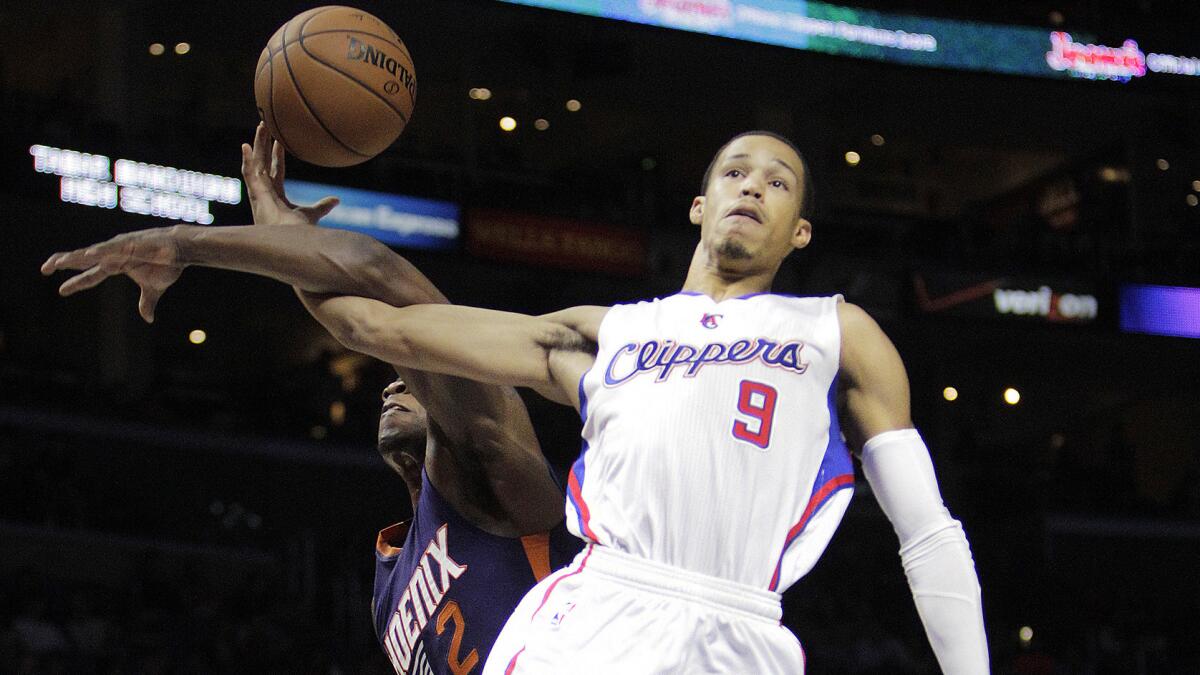 Clippers guard Jared Cunningham, right, is fouled by Phoenix Suns guard Eric Bledsoe while driving to the basket during the first half of the Clippers' exhibition win Wednesday.