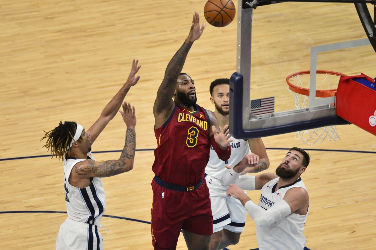 Cleveland Cavaliers center Andre Drummond (3) shoots between Memphis Grizzlies forwards Brandon Clarke, from right, and Kyle Anderson (1), and center Jonas Valanciunas (17) in the second half of an NBA basketball game Thursday, Jan. 7, 2021, in Memphis, Tenn. (AP Photo/Brandon Dill)