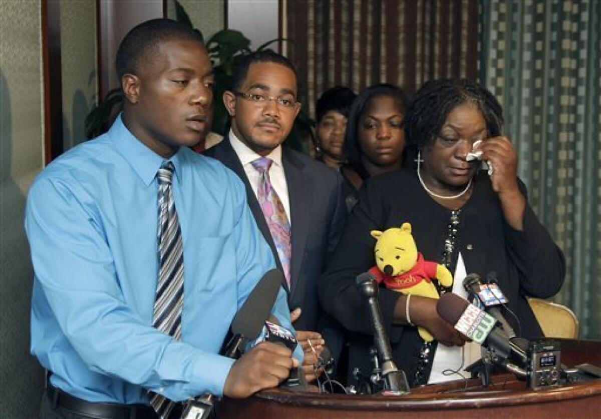 Willie Ferrell, left, talks about his older brother Jonathan A. Ferrell, who was shot to death early Saturday. Ferrell's mother, Georgia Ferrell, is at right, and family attorney Christopher Chestnut is at center.