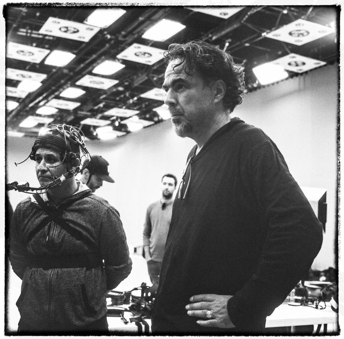 Alejandro G. I?árritu, right, on the set of "Carne y Arena" with a baker from El Salvador named Yoni, who is dressed in a motion-capture suit to help re-create a harrowing moment on his journey to the U.S. (Chachi Ramirez)