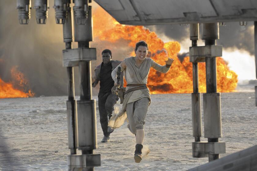 Daisy Ridley, right, as Rey, and John Boyega as Finn, in a scene from the film, "Star Wars: The Force Awakens."