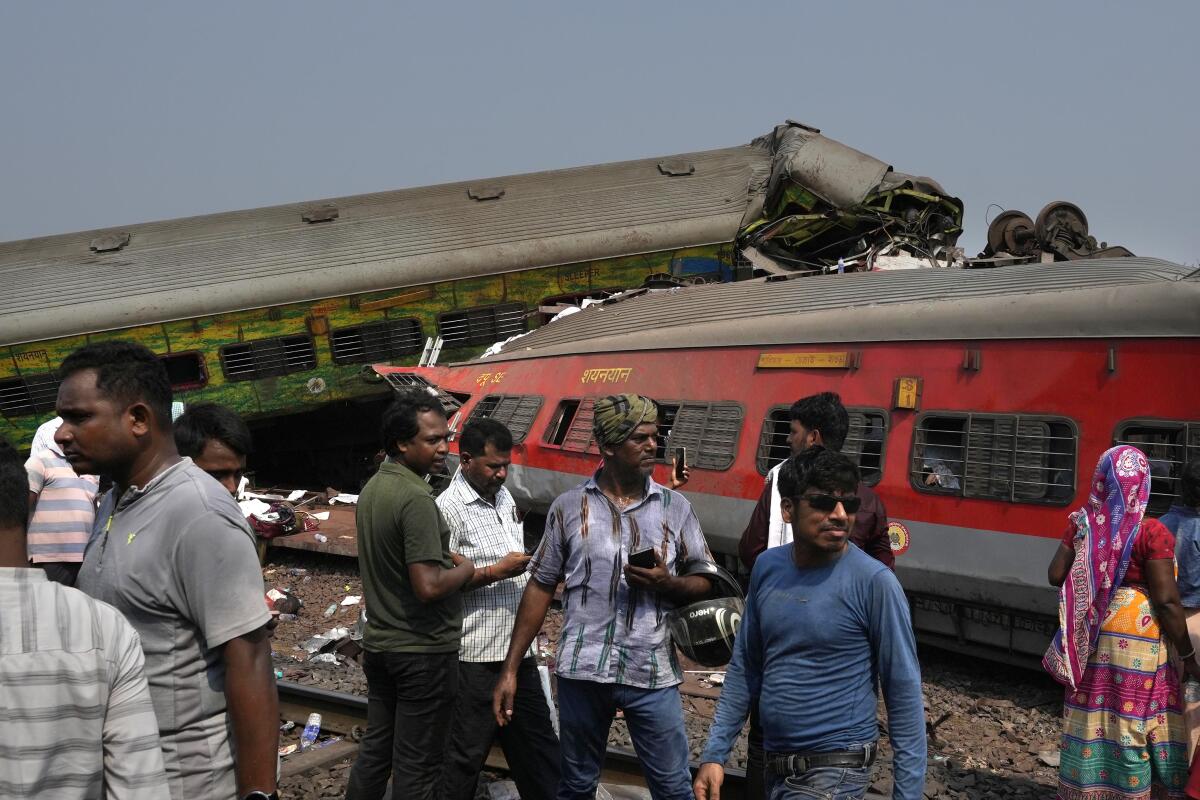 People inspect the site of passenger trains that derailed in Balasore district, in the eastern Indian state of Orissa