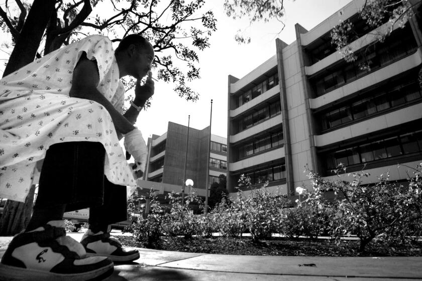 Albert Johnson, 46, who was admitted for a severe spider bite on his hand, sits outside the hospital for a smoke. "I brought it in a jar, I was sleeping and I felt something biting me."